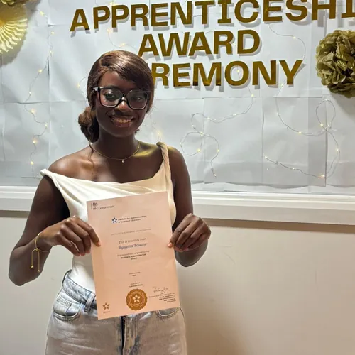 A learner holds her certificate at the Apprenticeship Award Ceremony.