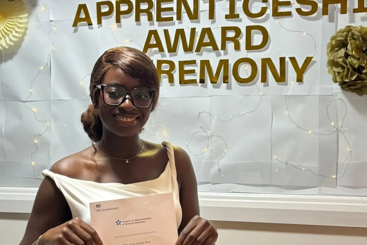 A Business Administrator Level 3 graduate holding her certificate at the Apprenticeship Award Ceremony.