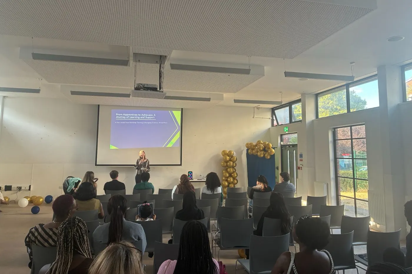 Learners and guests listening to a speaker at the From Apprentices to Achievers event.