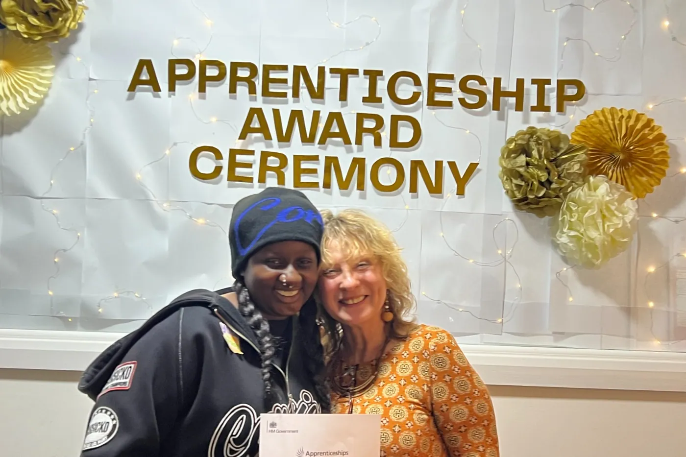 Two people smiling together with a certificate at the Apprenticeship Award Ceremony.
