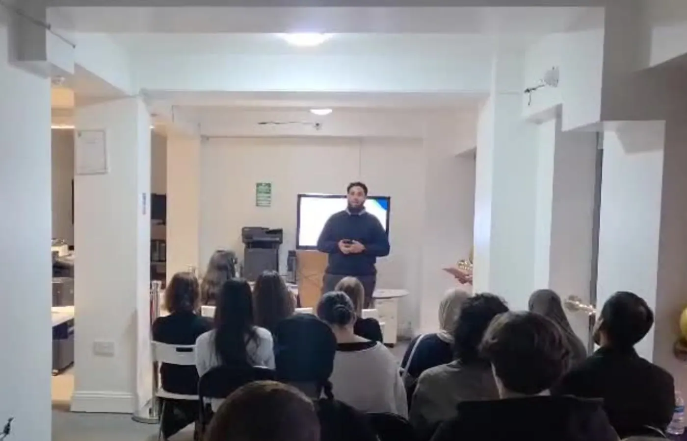 A presenter addressing a seated group at a NextStep event.